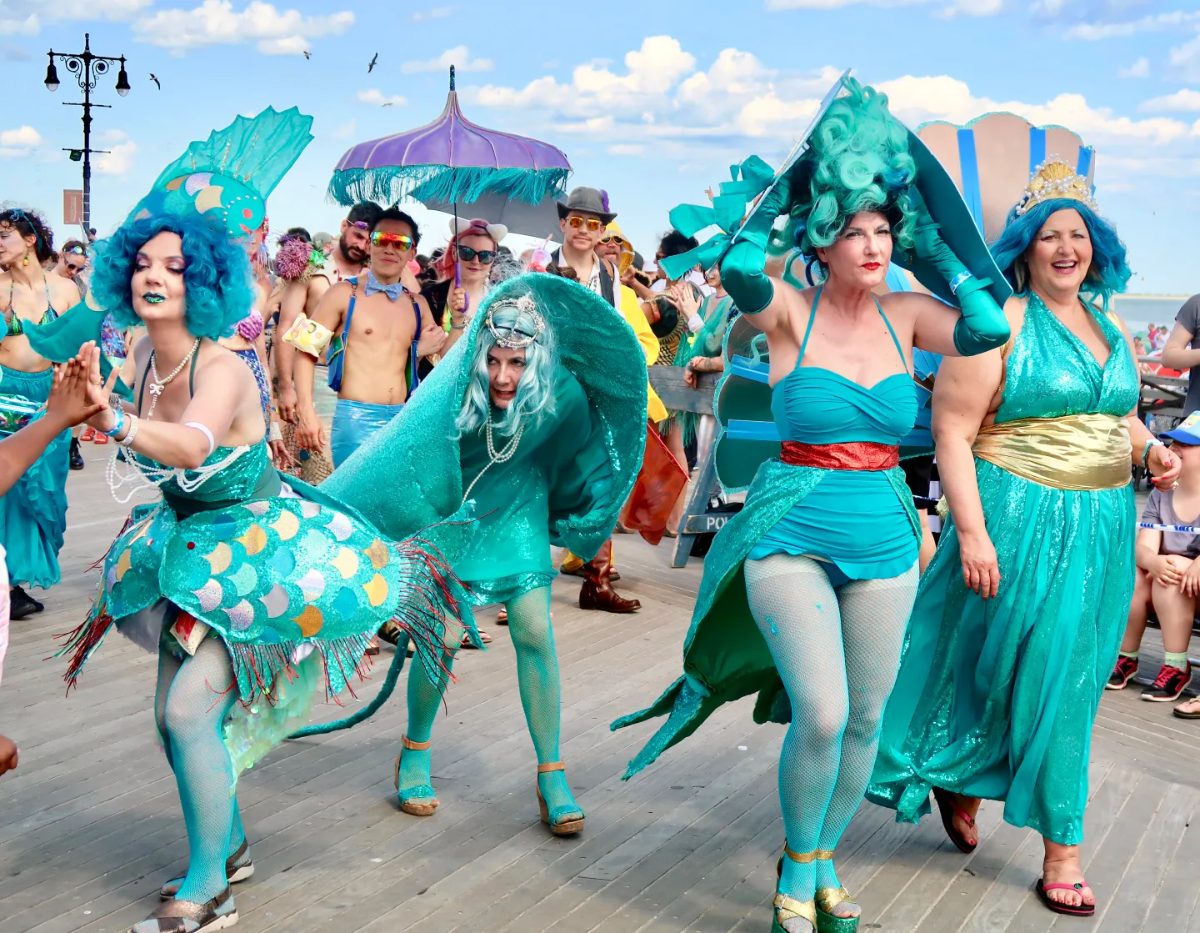 Mermaid Parade, with the Coney Island boardwalk and beach visible behind the crowd.