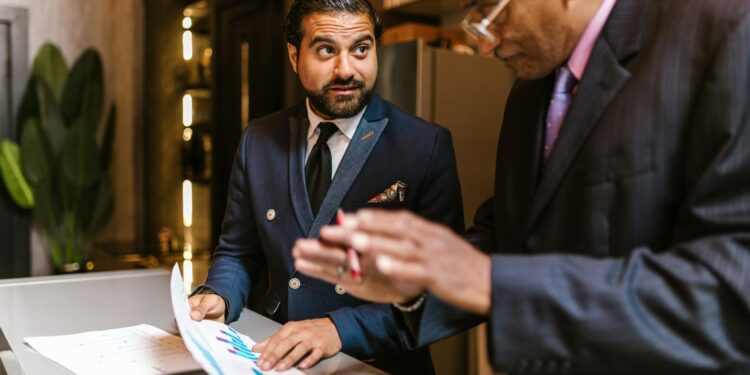 A small NYC business owner reviews mid-year finances at a counter, applying an NYC business strategy to manage rising costs.