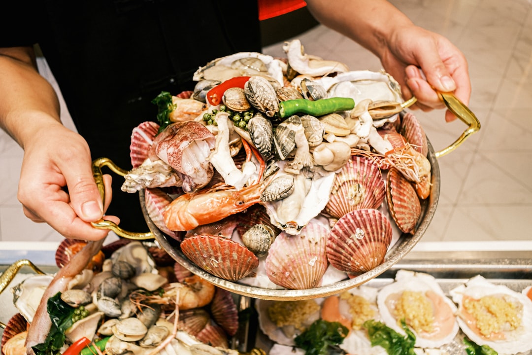 A chef carefully assembles lobster rolls in a New York City seafood restaurant kitchen, focusing on quality and freshness.