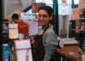 A woman business owner serves a customer inside her immigrant-owned shop in New York City