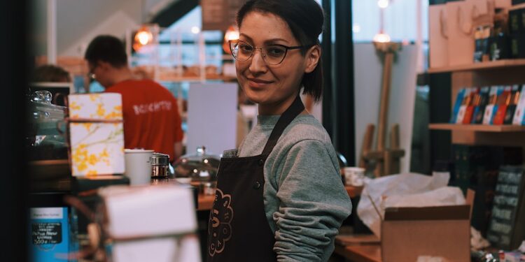 A woman business owner serves a customer inside her immigrant-owned shop in New York City