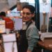 A woman business owner serves a customer inside her immigrant-owned shop in New York City