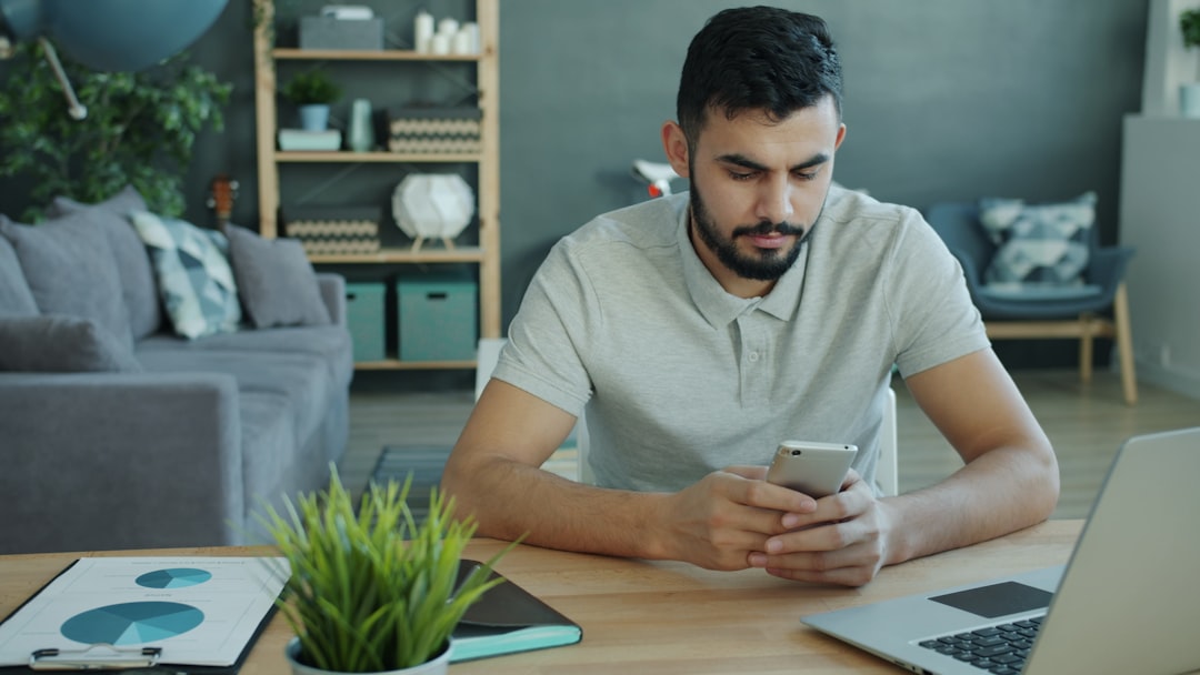 Un homme utilise son téléphone pour calculer les avantages à long terme de la création d'équité pour la propriété d'une coopérative de Brooklyn par rapport à la location à New York City.