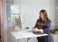 A woman entrepreneur reviews small business license documents at her New York City office desk