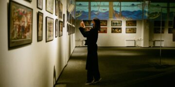 visitor-exploring-small-museum-exhibit-unsplash - NYCwebzine A visitor examines artifacts inside one of New York City's hidden museums in a quiet Lower East Side gallery