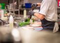 a-whole-chef-plating-fine-dining-dish-unsplash - NYCwebzine A chef carefully plates an elegant course at a Manhattan restaurant during restaurant week NYC, showcasing culinary craft.