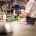 A chef carefully plates an elegant course at a Manhattan restaurant during restaurant week NYC, showcasing culinary craft.