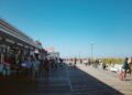 beach-boardwalk-summer-unsplash - NYCwebzine A woman walks along a sunny Jersey Shore boardwalk on a summer weekend trip from New York City