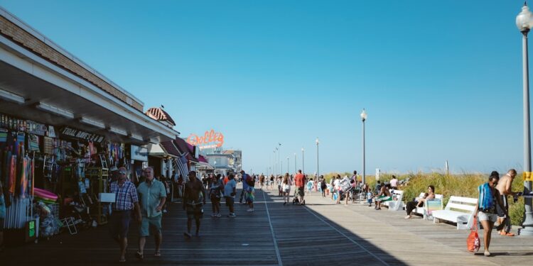 beach-boardwalk-summer-unsplash - NYCwebzine A woman walks along a sunny Jersey Shore boardwalk on a summer weekend trip from New York City