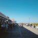 A woman walks along a sunny Jersey Shore boardwalk on a summer weekend trip from New York City