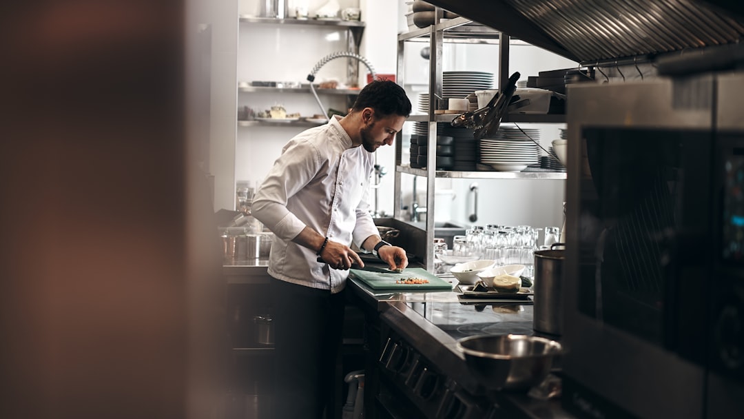 A chef plates a gluten-free dish in a New York City restaurant kitchen, reflecting the expansion of gluten-free menus.