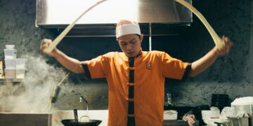 chef-serving-ramen-bowl-unsplash - NYCwebzine A chef carefully serves a steaming bowl at one of New York City's most celebrated ramen shops