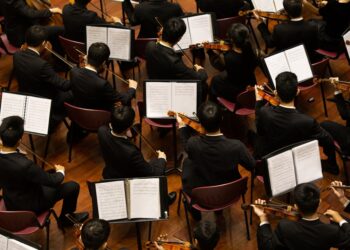A conductor leads the Festival Orchestra of Lincoln Center in a Mostly Mozart concert at David Geffen Hall