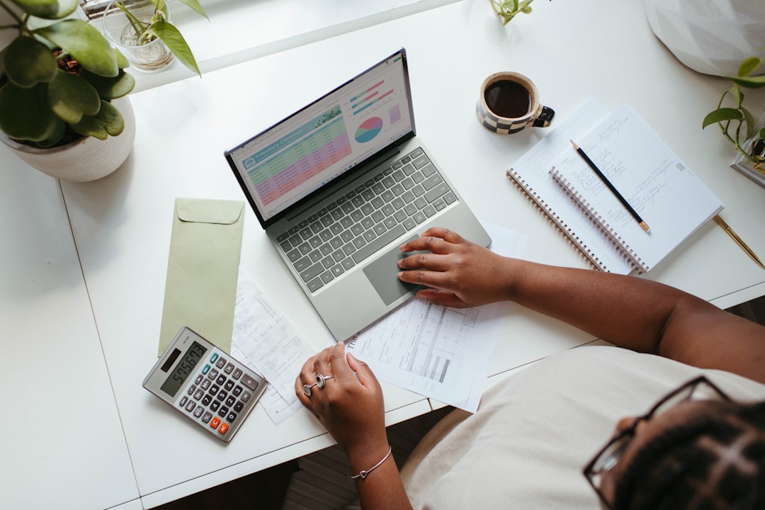 An entrepreneur at a desk reviews cash flow data to help his small business prepare for slow summer weeks in New York City.