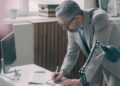 entrepreneur-signing-office-lease-unsplash - NYCwebzine A first-time business owner reviewing a commercial lease agreement at a desk in a New York City office