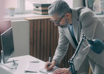 A first-time business owner reviewing a commercial lease agreement at a desk in a New York City office
