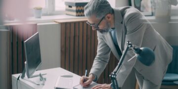 A first-time business owner reviewing a commercial lease agreement at a desk in a New York City office