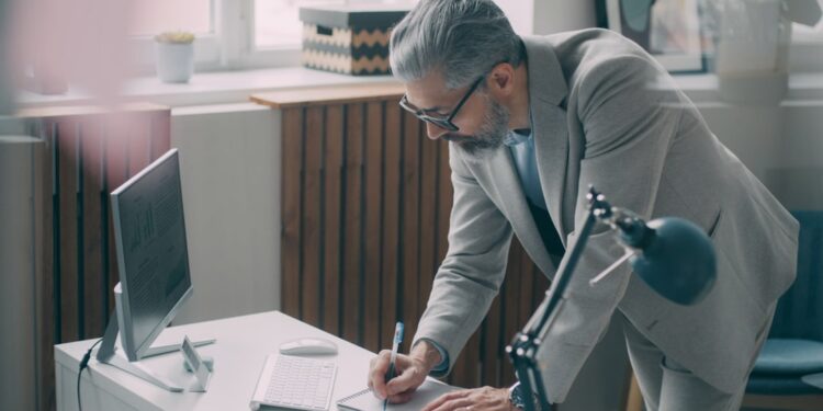 A first-time business owner reviewing a commercial lease agreement at a desk in a New York City office