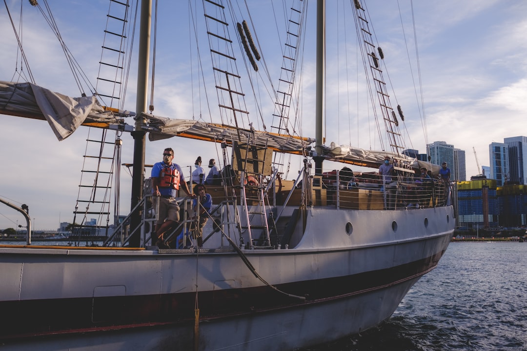 A family walks the gangway to board a historic tall ship during the free Sail4th 250 public ship tours at a New York City.