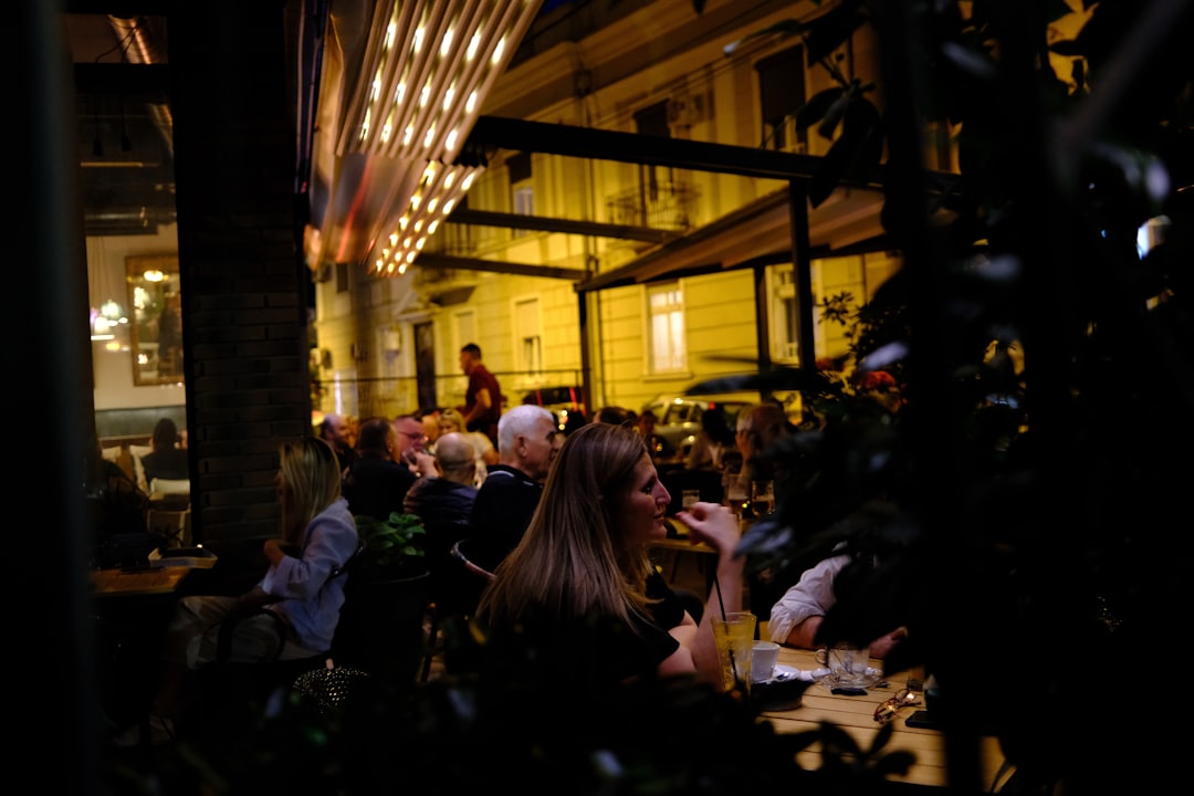 A group of friends laughing over dinner at an outdoor dining patio table in NYC
