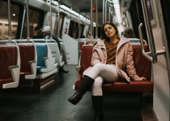 A woman descends into a New York City subway station, embracing car-free living in the urban landscape below the street.