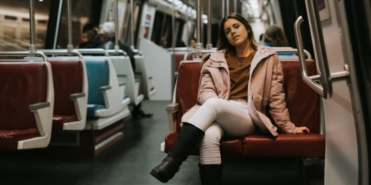 A woman descends into a New York City subway station, embracing car-free living in the urban landscape below the street.