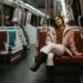 A woman descends into a New York City subway station, embracing car-free living in the urban landscape below the street.