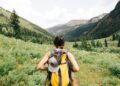 hiking-trail-woman-unsplash - NYCwebzine A woman pauses on a wooded trail during a Hudson Valley weekend hike, with green hills visible behind her