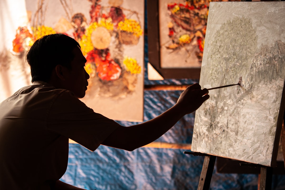A man works on a watercolor painting at a table during one of the free art classes offered across New York City