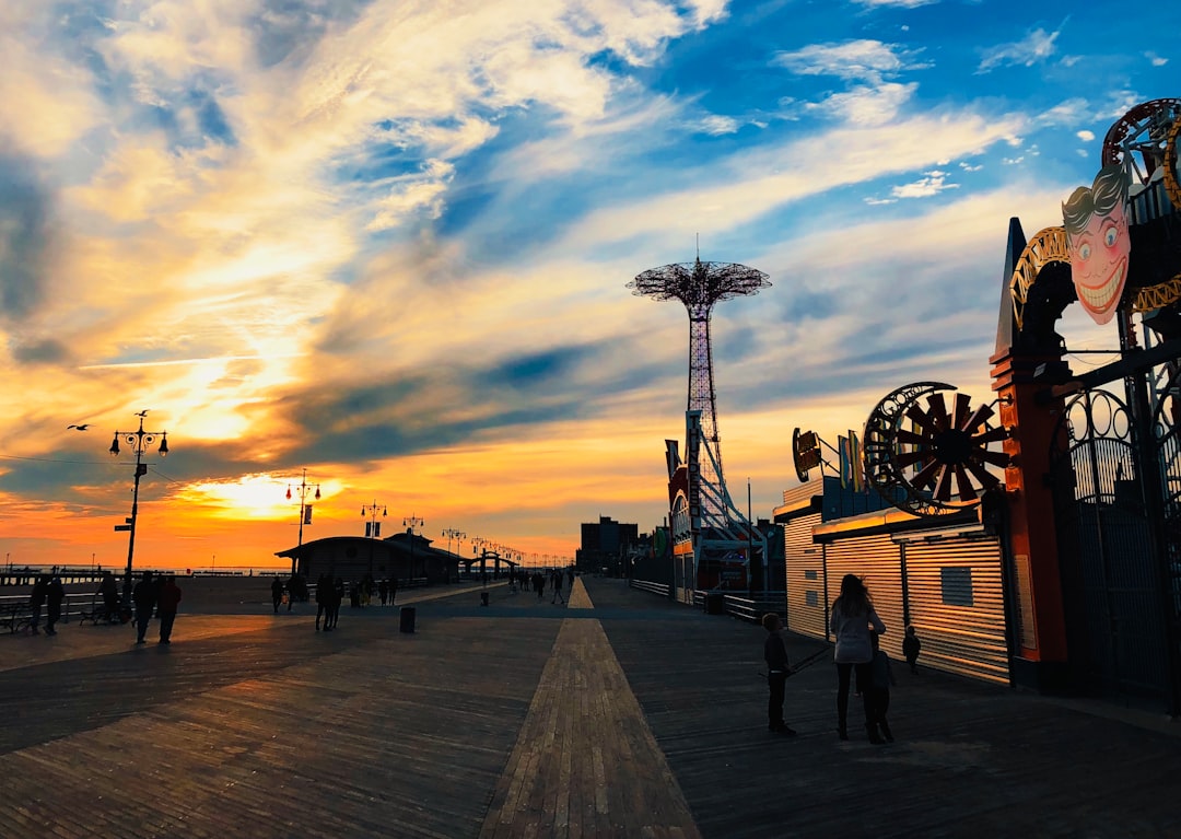 A person filming the Coney Island boardwalk in summer, capturing the vibrant energy of outdoor photography in NYC