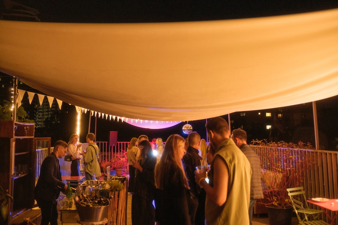 A group of friends raising cocktail glasses during a rooftop dining evening above the New York City skyline