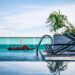 rooftop-pool-relaxation-unsplash - NYCwebzine A woman resting by one of Manhattan's rooftop pools on a sun-drenched terrace with city skyline views behind her