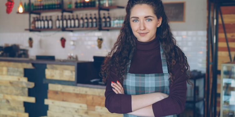 small-business-owner-portrait-unsplash - NYCwebzine A small business owner stands in front of her New York City shop, reviewing everything to keep her small business thriving.