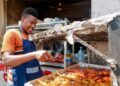 west-african-food-restaurant-unsplash - NYCwebzine A West African man serves a bowl of fufu and soup at a busy Bronx restaurant, representing the heart of the West African food