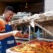 west-african-food-restaurant-unsplash - NYCwebzine A West African man serves a bowl of fufu and soup at a busy Bronx restaurant, representing the heart of the West African food