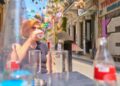 woman-drinking-water-city-summer-unsplash - NYCwebzine A woman staying hydrated on a New York City street, showing how to stay cool during July heat