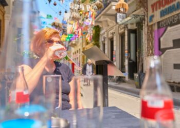 woman-drinking-water-city-summer-unsplash - NYCwebzine A woman staying hydrated on a New York City street, showing how to stay cool during July heat