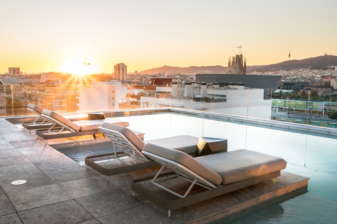 A woman reading on a lounge chair beside one of Manhattan's rooftop pools, with skyscrapers visible in the background