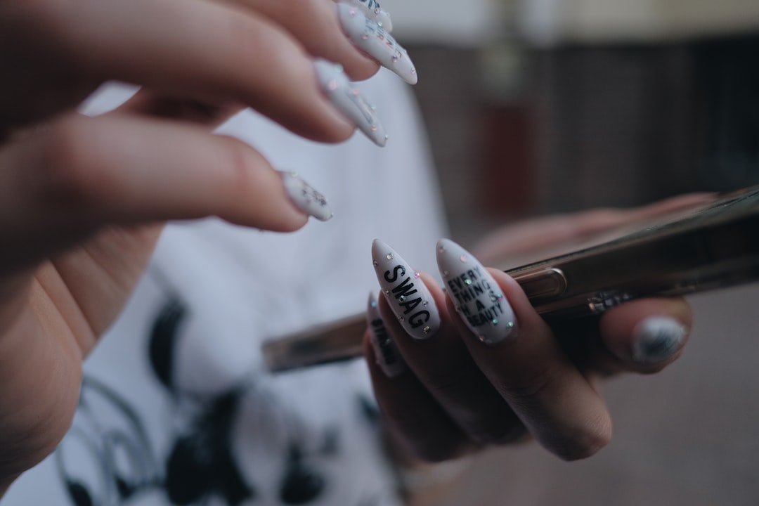A client reviews bold nail art designs with her technician at a creative nail salon in New York City