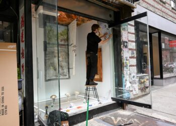 A painter working at an easel in a New York studio space, representing the focused time that artist residencies provide.