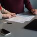 A small business owner reviews an employment contract before bringing on their first employee in New York City