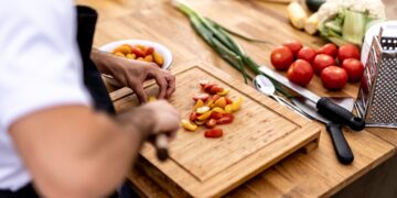 chef-plating-heirloom-tomato-salad-unsplash - NYCwebzine A chef carefully plates a vibrant heirloom dish featuring August tomatoes at a New York City farm-to-table restaurant.