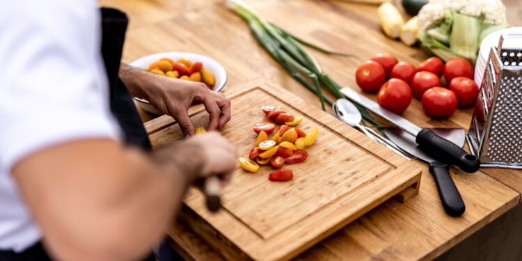 chef-plating-heirloom-tomato-salad-unsplash - NYCwebzine A chef carefully plates a vibrant heirloom dish featuring August tomatoes at a New York City farm-to-table restaurant.