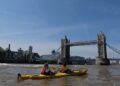 child-kayaking-river-city-unsplash - NYCwebzine A child paddling a kayak on the East River during a family kids adventure at Brooklyn Bridge Park in New York City