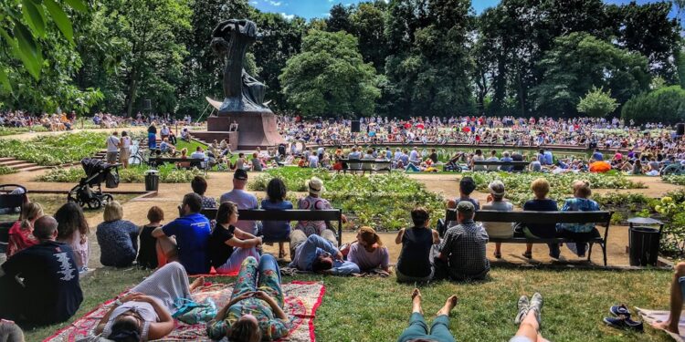 crowd-enjoying-outdoor-concert-park-unsplash - NYCwebzine A diverse crowd of people enjoying free outdoor concerts in a New York City park on a summer evening