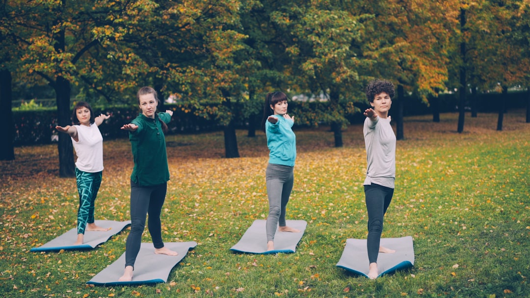 A group of people in an outdoor fitness bootcamp class running together in a NYC park