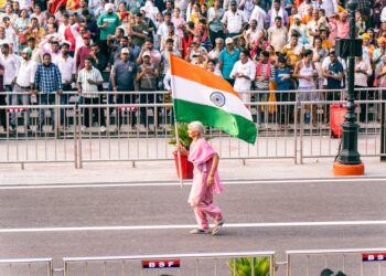 A woman in traditional dress waves the Indian flag during the India Day parade on Madison Avenue in New York City