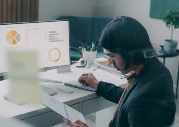 A financial analyst reviewing NYC REITs performance data on a screen in a Manhattan office