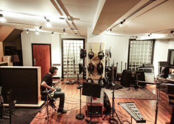 An independent artist recording vocals in an affordable studio space in New York City