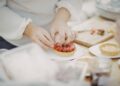 pastry-chef-plating-summer-dessert-unsplash - NYCwebzine A pastry chef carefully plates a late summer dessert at a New York City restaurant, showcasing seasonal fruit.